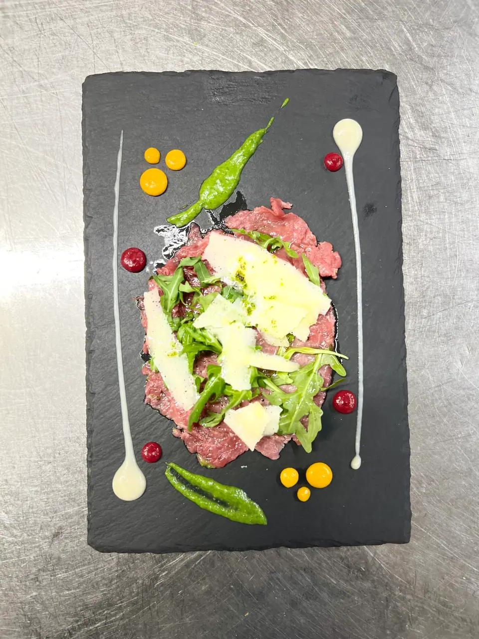 Fertiges Carpaccio mit frischer Rucola und Soßen